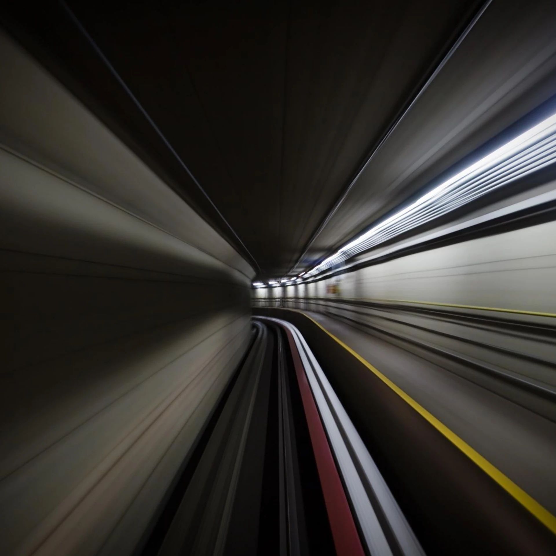 A high-speed view through a tunnel with streaks of light and lines creating a sense of motion and energy. The abstract composition emphasizes speed and innovation.